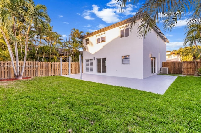 rear view of property with central AC unit, a patio area, and a yard