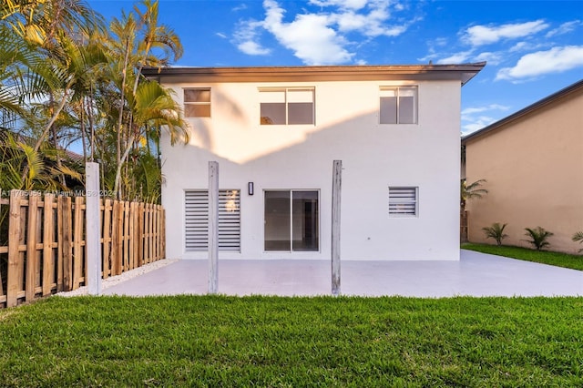 back of property featuring a yard and a patio