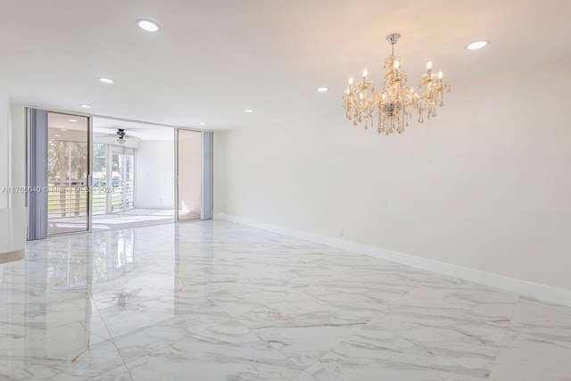 spare room featuring floor to ceiling windows and ceiling fan with notable chandelier