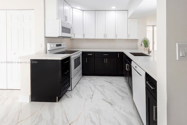 kitchen with white cabinets, white appliances, light stone countertops, and sink