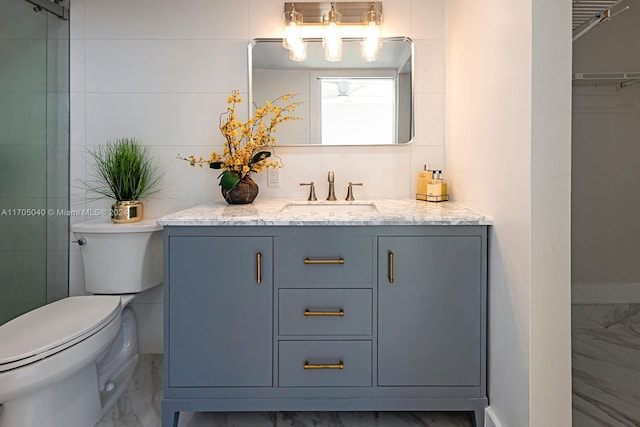 bathroom featuring vanity, tile walls, and toilet