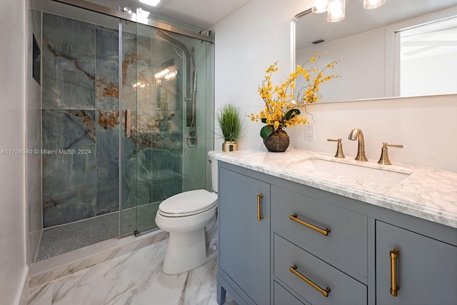 bathroom featuring vanity, a shower with shower door, and toilet