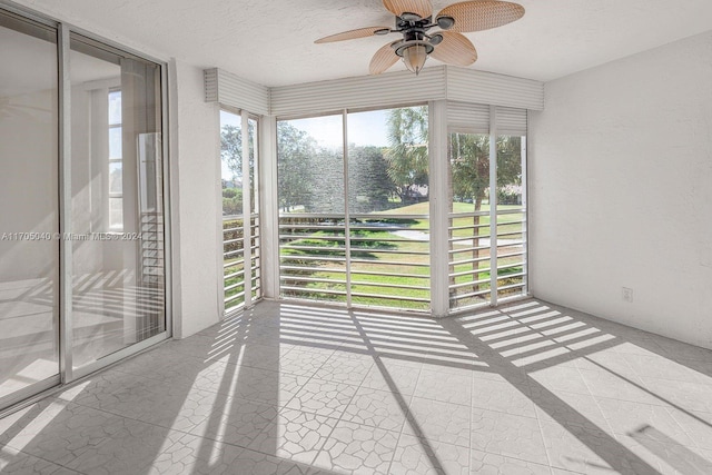 unfurnished sunroom with ceiling fan