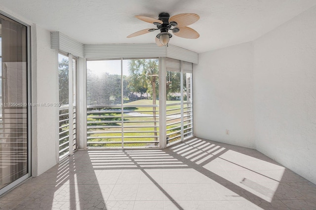 unfurnished sunroom featuring a wealth of natural light and ceiling fan