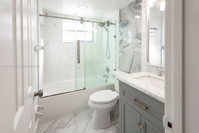 full bathroom featuring vanity, toilet, and bath / shower combo with glass door