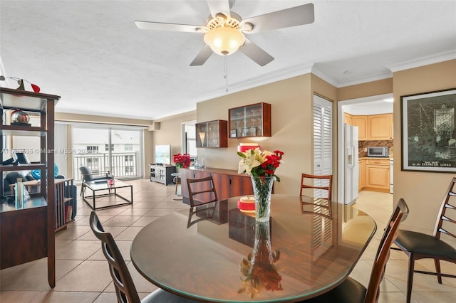 tiled dining room with crown molding, ceiling fan, and a textured ceiling