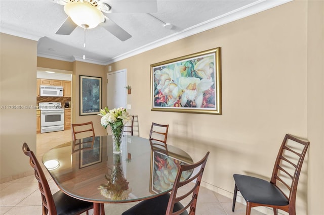 tiled dining room with ceiling fan, ornamental molding, and a textured ceiling