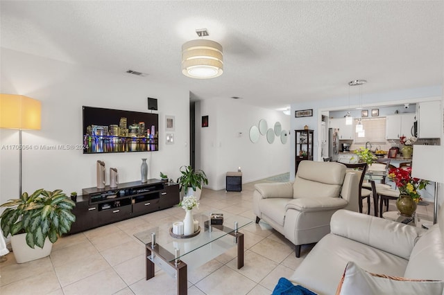 tiled living room featuring a textured ceiling