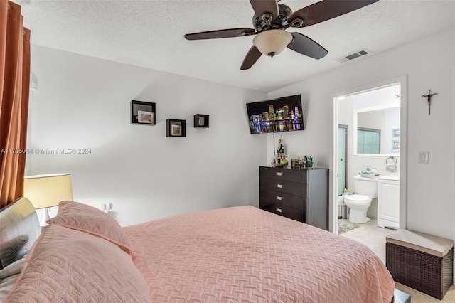 bedroom featuring a textured ceiling, ceiling fan, and ensuite bathroom