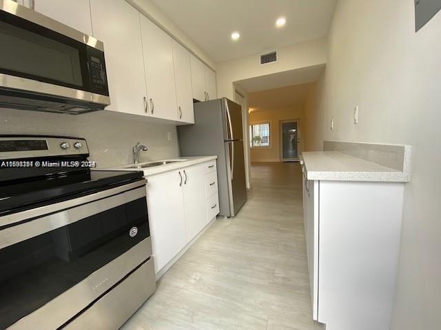 kitchen with white cabinetry, sink, and appliances with stainless steel finishes