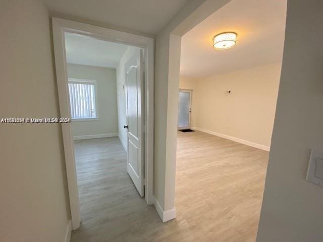 corridor with light hardwood / wood-style floors