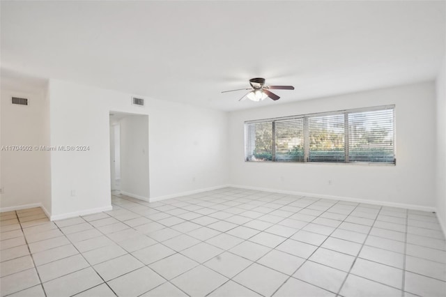 tiled spare room with ceiling fan