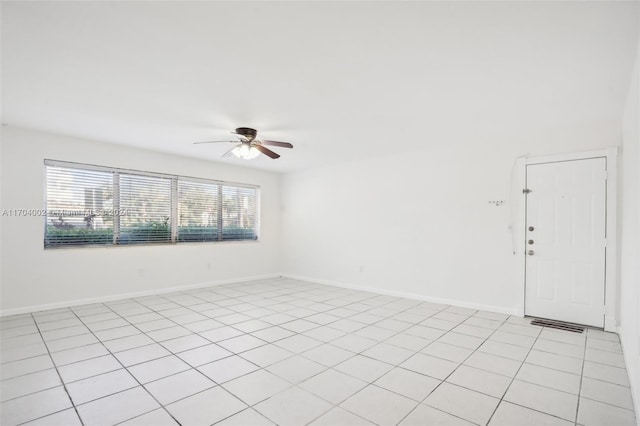 spare room with ceiling fan and light tile patterned flooring