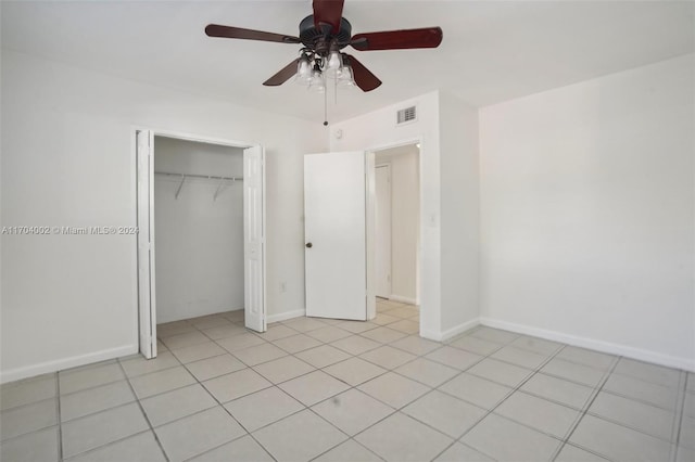 unfurnished bedroom with ceiling fan, light tile patterned floors, and a closet