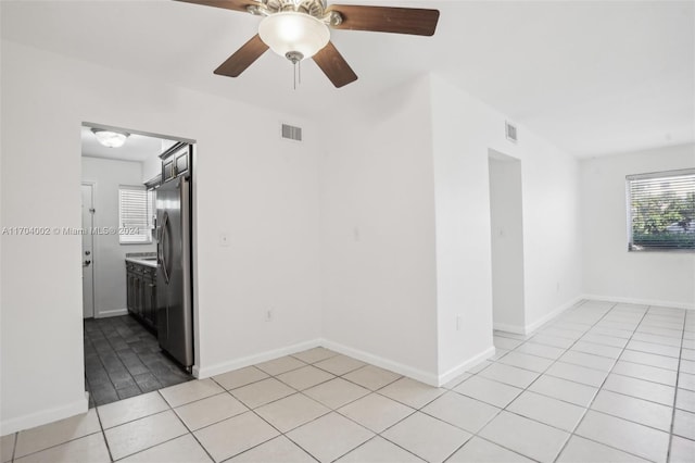 unfurnished room with ceiling fan and light tile patterned flooring