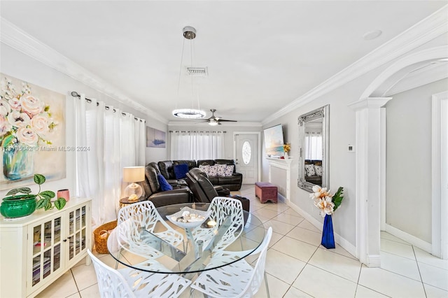 dining space featuring ceiling fan, light tile patterned floors, crown molding, and decorative columns