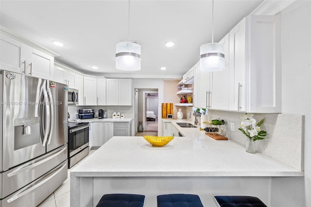 kitchen featuring a breakfast bar area, kitchen peninsula, white cabinetry, and appliances with stainless steel finishes