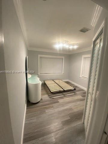 hallway featuring hardwood / wood-style flooring and crown molding