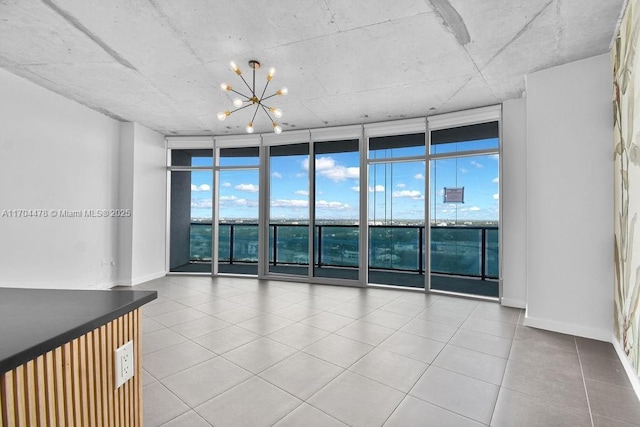 spare room featuring expansive windows and a notable chandelier