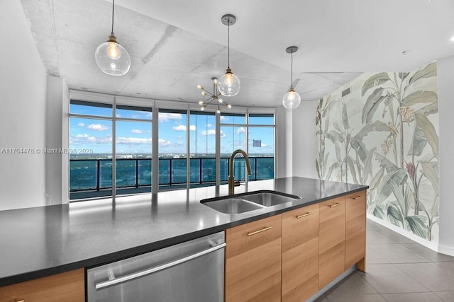 kitchen with stainless steel dishwasher, floor to ceiling windows, sink, pendant lighting, and a water view