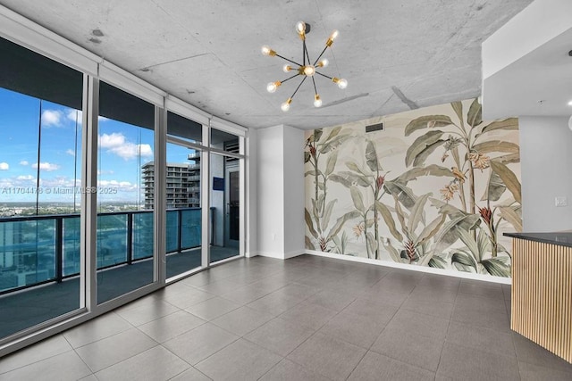 empty room featuring a chandelier and a wall of windows