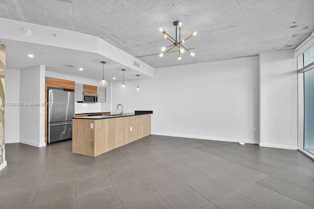 kitchen with sink, a chandelier, decorative light fixtures, and appliances with stainless steel finishes