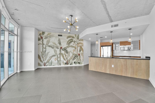 unfurnished living room with a wealth of natural light and a chandelier