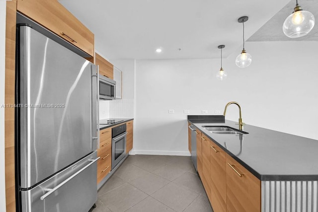 kitchen with kitchen peninsula, backsplash, stainless steel appliances, sink, and pendant lighting