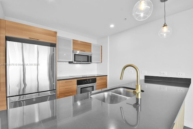 kitchen featuring appliances with stainless steel finishes, backsplash, hanging light fixtures, and sink