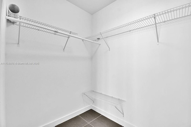 spacious closet featuring dark tile patterned flooring