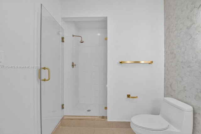 bathroom with tile patterned flooring, an enclosed shower, and toilet