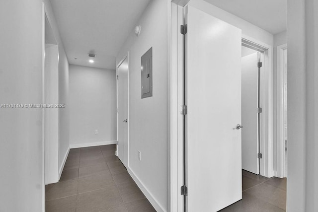 corridor featuring dark tile patterned floors and electric panel