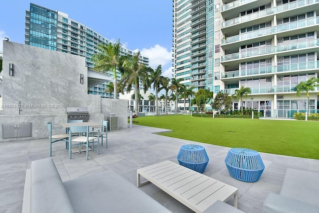 view of home's community featuring a lawn, a patio area, and sink