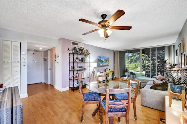 dining room featuring ceiling fan, light hardwood / wood-style floors, and a textured ceiling