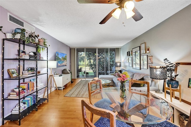 dining room with ceiling fan, a textured ceiling, and light wood-type flooring