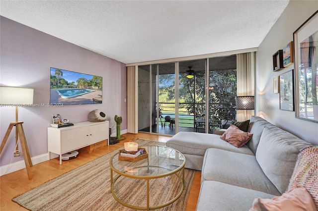 living room with hardwood / wood-style floors, ceiling fan, and a textured ceiling