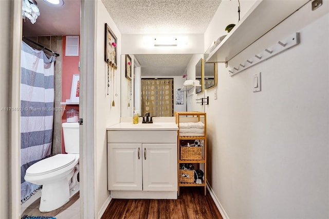 bathroom featuring vanity, toilet, a textured ceiling, curtained shower, and wood-type flooring