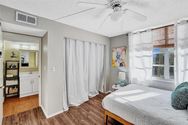 bedroom with hardwood / wood-style flooring, ceiling fan, and a textured ceiling