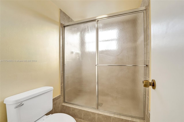 bathroom featuring an enclosed shower and toilet