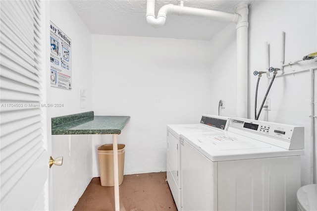 clothes washing area featuring washer and dryer and a textured ceiling