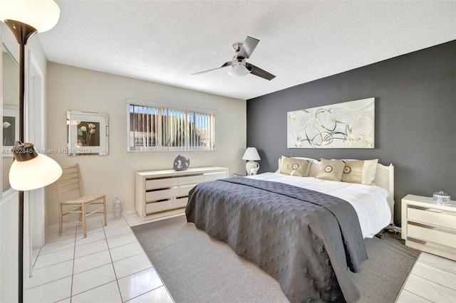 tiled bedroom with a textured ceiling and ceiling fan