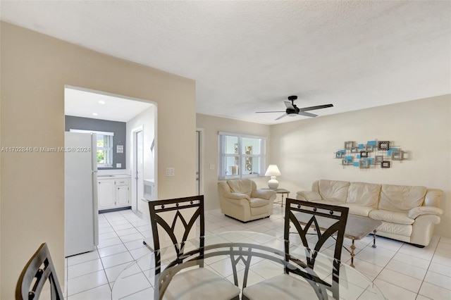 living room with ceiling fan, light tile patterned floors, a healthy amount of sunlight, and a textured ceiling