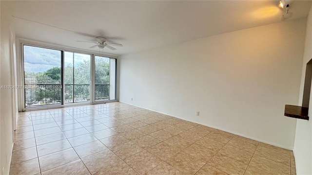 tiled spare room featuring ceiling fan