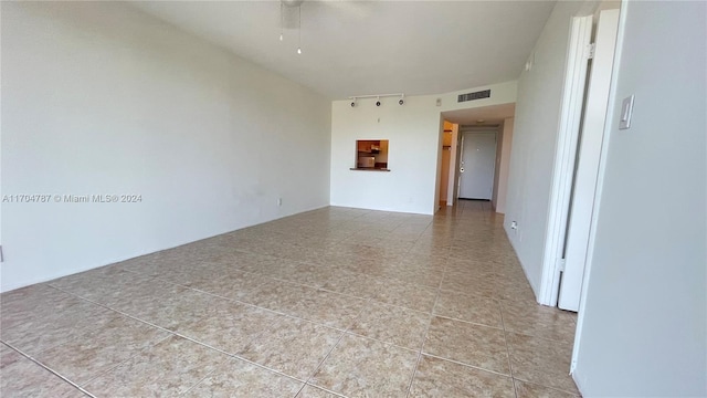 unfurnished room with light tile patterned floors and ceiling fan