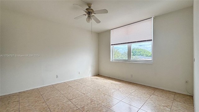 tiled spare room with ceiling fan