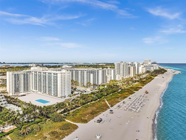 birds eye view of property with a water view and a beach view