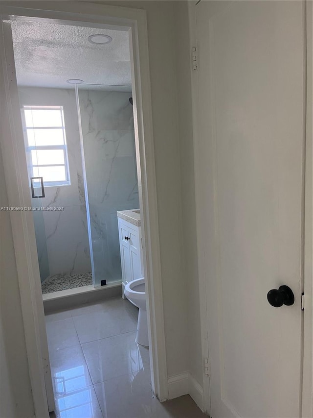 bathroom featuring vanity, tile patterned floors, toilet, a textured ceiling, and walk in shower