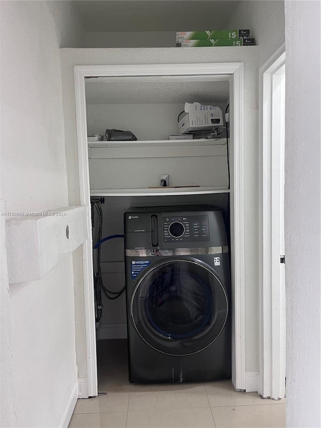 laundry area with light tile patterned floors and washer / clothes dryer