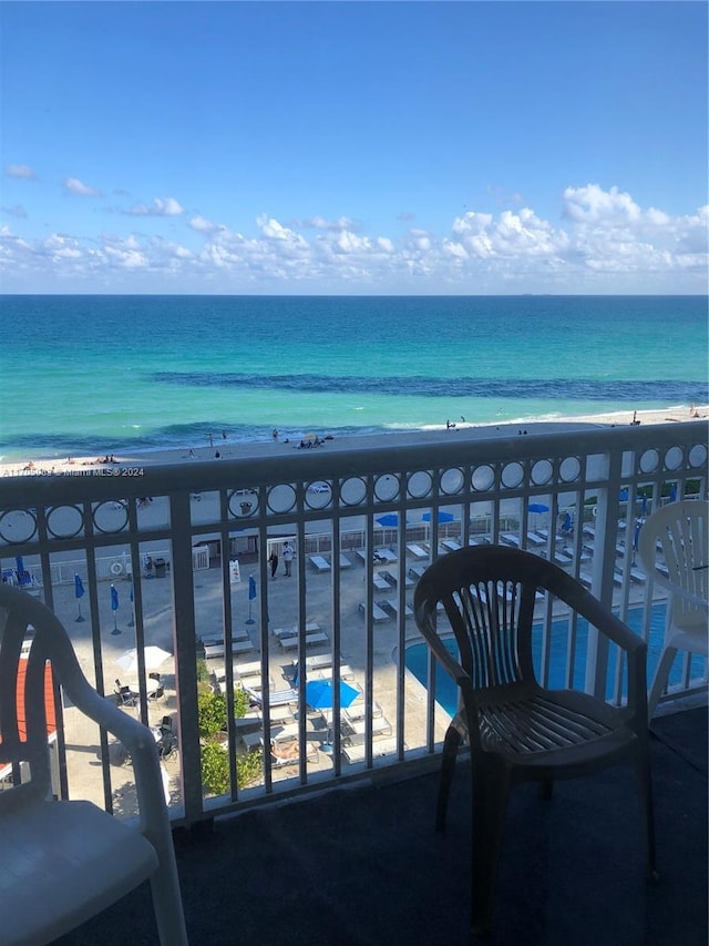 balcony featuring a beach view and a water view