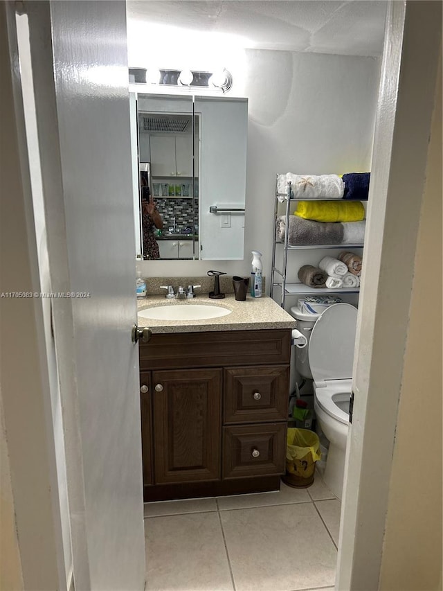 bathroom with tile patterned flooring, vanity, and toilet